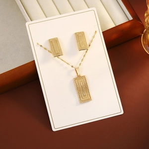 Detail of gold rectangular geometric texture necklace and earrings jewelry set on display