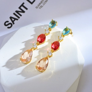 Detailed close-up of multicolor teardrop gemstone earrings featuring gold-plated claw setting