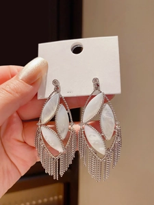 Detailed macro view of vintage hollow oval tassel earrings with sparkling shell inlay