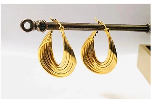 Detailed close-up of 18K gold-plated stainless steel earrings with twisted wave design