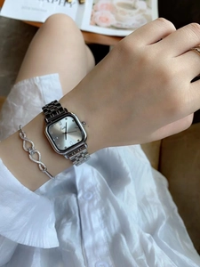 Close-up of elegant square silver watch and infinity bracelet on woman wrist