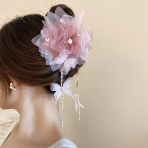 Detail of pink mesh flower hair claw with rhinestone butterfly tassels and soft petals