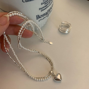 Elegante collana a doppio strato con perle e ciondolo a cuore in argento scintillante