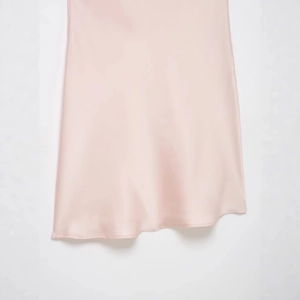 Robe nuisette en satin de soie rose avec dentelle présentée en suspension