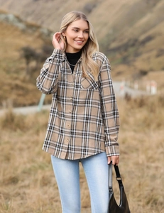 Close-up of classic plaid pattern and single pocket on a brown long-sleeve casual shirt