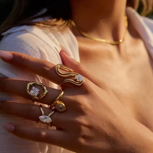 Elegant gold titanium rings set for women with zircon crystals in warm sunset lighting