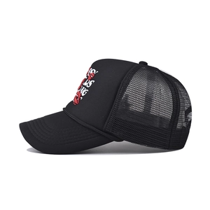 Détail de la broderie lèvres rouges et du texte 'Stay Strong' sur une casquette en filet