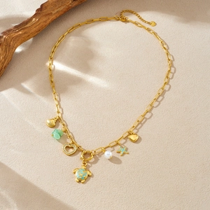 Gold ocean necklace with blue turtle, seashell, green stone, and starfish pendants