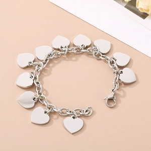 Detailed macro view of silver steel link bracelet with ten polished heart charms