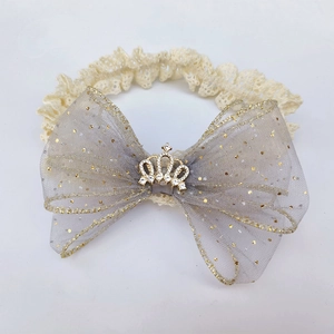 Detailed view of lace baby headband with large glitter mesh bow and rhinestone crown