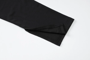 Detail view of the side slit and high-quality fabric stitching on the black dress sleeve