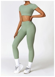Détail du haut court vert menthe et du legging de yoga taille haute sur profil modèle