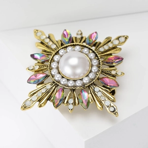 Detailed macro view of baroque sun flower brooch with pearls and colorful crystals