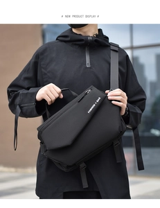 Outdoor city shot of a black nylon crossbody bag with fashion print and adjustable strap
