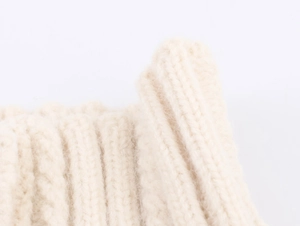 Détail macro de la texture en maille côtelée beige et du tissu doux du pull de Noël