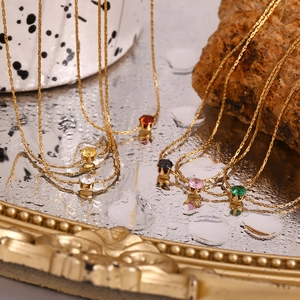 Detail of 18K gold-plated woven chain necklaces with colorful zircon gems on mirror