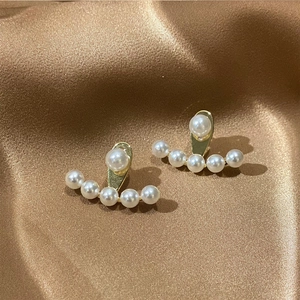 Detail of elegant gold base pearl earrings with a fan-shaped arrangement of white pearls