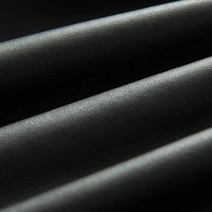 Macro shot of high-quality black faux leather texture with natural lychee grain details