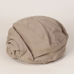 Detailed close-up of khaki linen newsboy hat showing breathable pleated fabric texture