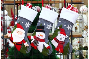 Detail of 3 grey felt Christmas stockings with 3D Santa, snowman and polar bear motifs