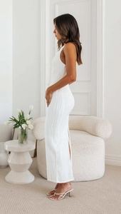 Close-up of white bodycon maxi dress in textured rippled fabric and side slit detail