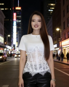 Detail of white short sleeve top with corset-style lace patchwork and eyelash lace hem
