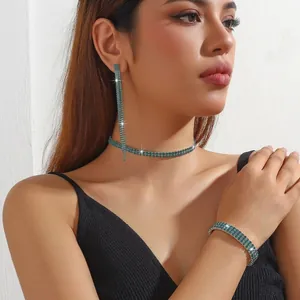 Detail shot of sparkling green rhinestone fringe earrings and layered necklace set