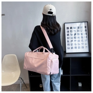 Pink large capacity sports gym bag with side pocket shown on shoulder by model