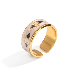 Detail showing the adjustable gold wide band ring with pink enamel and evil eye pattern