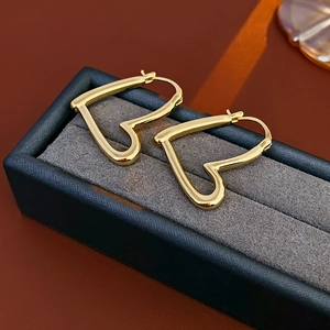 Vue rapprochée de boucles d'oreilles cœur dorées dans un coffret cadeau luxe