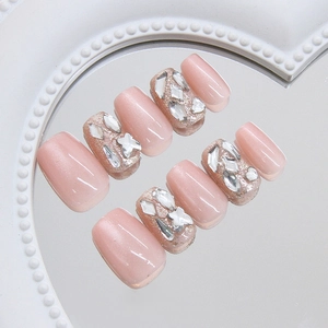 Pink cat eye press-on nails with sparkling rhinestones on a heart mirror base