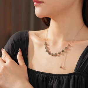 Detail of rose gold necklace with dark floral crystals on a model's neck