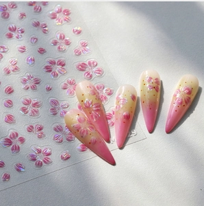 Macro detail of 3D embossed pink cherry blossom nail stickers with pearlescent finish