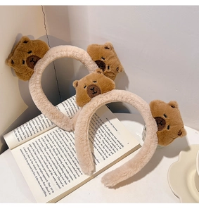 Detail of plush beige headbands with cute brown bear figures on an open book