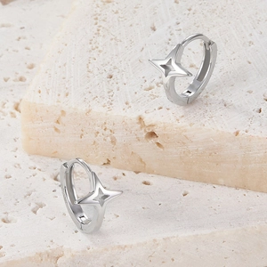 Macro detail of S925 sterling silver star-shaped hoop earrings on natural stone background