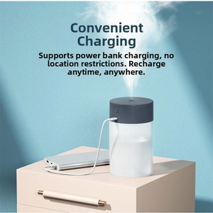 USB portable humidifier connected to power bank emitting fine mist on a desk