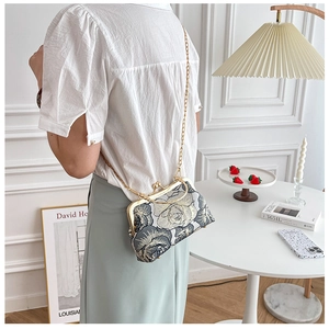 Exquisite floral embroidery cheongsam evening bag with a gold chain strap on a model
