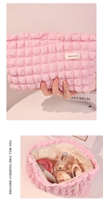 Detalle del neceser rosa con textura de burbujas mostrando gran capacidad interna