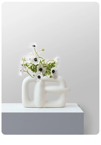 Detail of modern white ceramic geometric hollow vase with matte finish for home decor