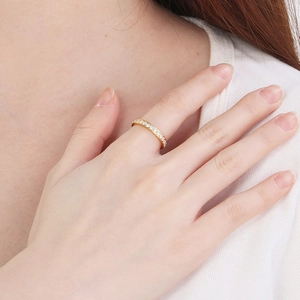 Close-up of a minimalist gold stainless steel ring with micro-pave diamonds on a hand