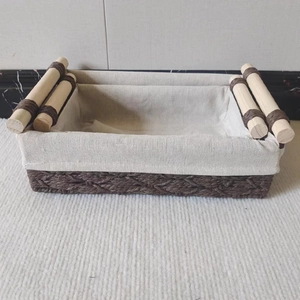 Detail of woven paper rope storage basket with white fabric liner and wooden handles