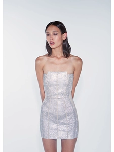Détail de la texture des paillettes argentées sur une robe courte bustier moulante
