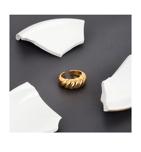 Detailed view of adjustable gold croissant twisted ring with glossy spiral texture