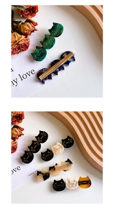 Close-up of cat-shaped acetate hair clips in marble green and floral patterns