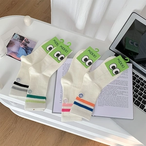 Close-up of white cotton crew socks with colorful striped cuffs and rib-knit texture