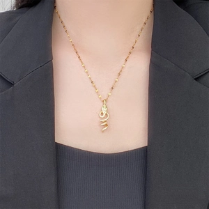 Close-up of vintage gold snake pendant necklace with zircon inlay on a female neck