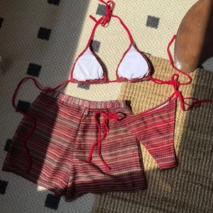 Drei-teiliger Häkel-Bikini-Set mit rot-weiß-schwarzen Streifen in Flachlege-Ansicht
