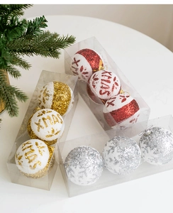 Detailed view of glitter Christmas ornaments with XMAS text in transparent gift boxes