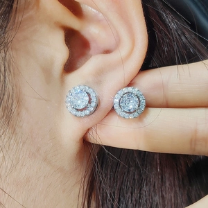Macro shot of silver stud earrings featuring a large round zircon with a halo of small diamonds
