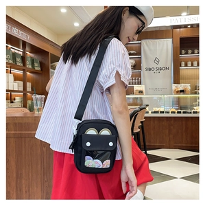 Detail of a black canvas ita bag with a clear window and cute bear ears on the flap
